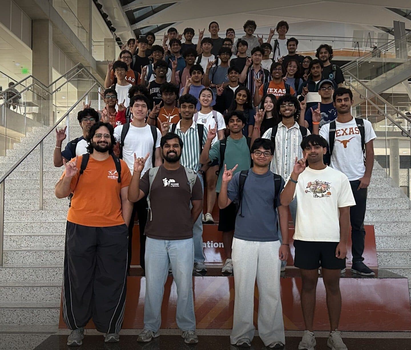 The Longhorn Silicon group posing on the EER stairs, holding up the Hook 'em sign